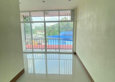 Empty living room with large windows and balcony view