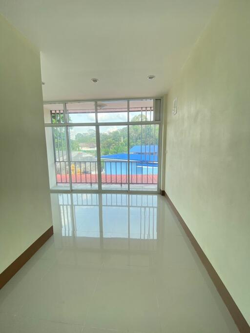 Empty living room with large windows and balcony view