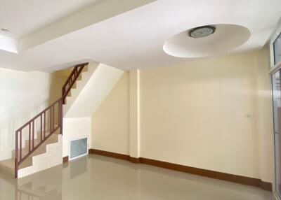 A spacious, empty living room with staircase