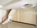 A spacious, empty living room with staircase