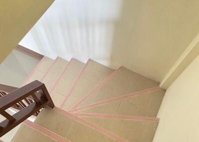 View of the staircase with tiled steps and wooden railing