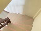 View of the staircase with tiled steps and wooden railing