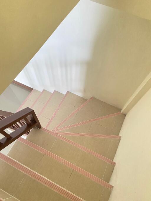 View of the staircase with tiled steps and wooden railing