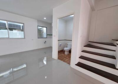 Spacious living area with a view of a staircase and a bathroom