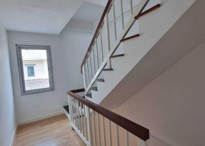 Staircase with wooden steps and white railings