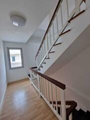 Staircase with wooden steps and white railings