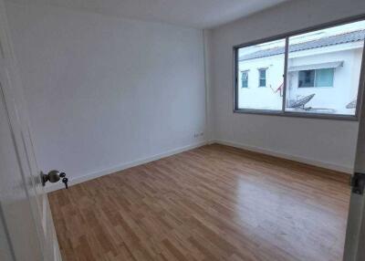 Empty bedroom with wooden floor and large window