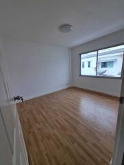 Empty bedroom with wooden floor and large window