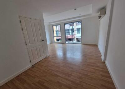 Spacious empty living room with wooden flooring and large windows