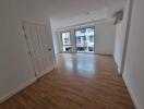 Spacious empty living room with wooden flooring and large windows