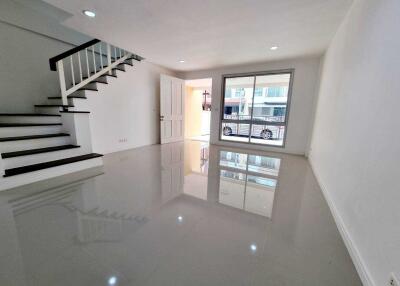 Spacious living room with a staircase and large window