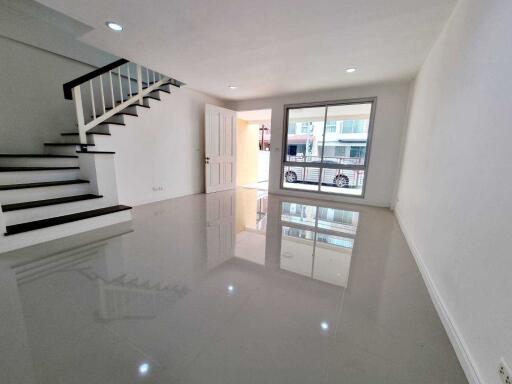 Spacious living room with a staircase and large window