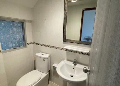 Modern bathroom with white fixtures and tiled walls