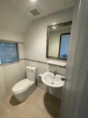 Modern bathroom with white fixtures and tiled walls