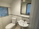 Modern bathroom with white fixtures and tiled walls