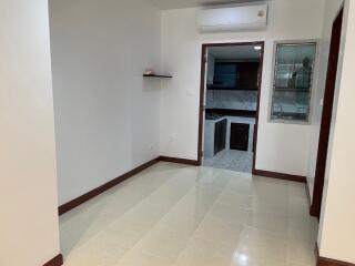 Simple living area with door leading to the kitchen