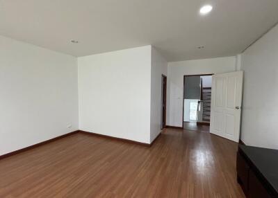 Spacious empty bedroom with wooden flooring and white walls