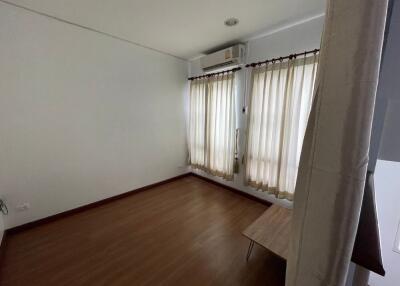 Bedroom with wooden floor and light curtains