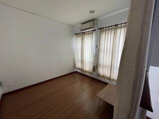 Bedroom with wooden floor and light curtains