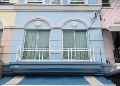 Three-story residential building with a blue facade