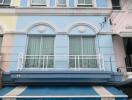 Three-story residential building with a blue facade