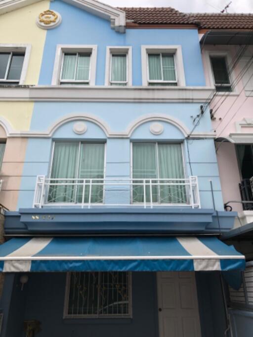 Three-story residential building with a blue facade