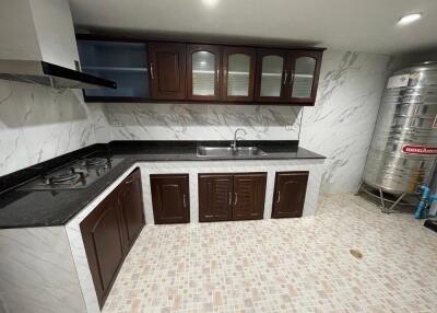 Modern kitchen with tiled floor, dark wood cabinets, and stainless steel appliances