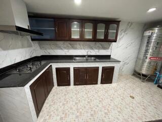 Modern kitchen with tiled floor, dark wood cabinets, and stainless steel appliances