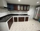 Modern kitchen with tiled floor, dark wood cabinets, and stainless steel appliances