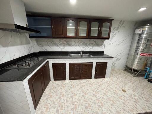 Modern kitchen with tiled floor, dark wood cabinets, and stainless steel appliances