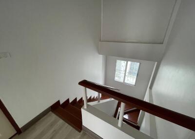 View of the building staircase with white walls and wooden handrails