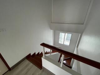 View of the building staircase with white walls and wooden handrails