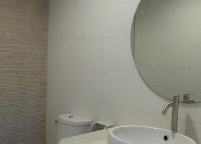 Modern bathroom with round mirror and white fixtures