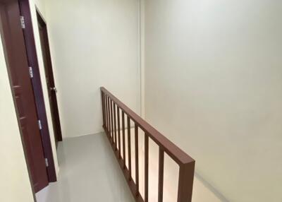 A hallway with stairs and a handrail