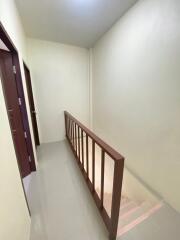 A hallway with stairs and a handrail