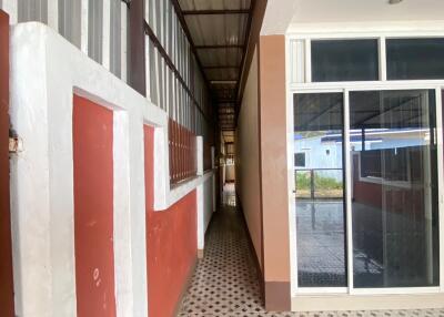 Corridor outside a building with tiled flooring and glass doors