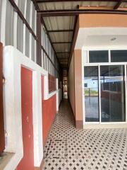 Corridor outside a building with tiled flooring and glass doors