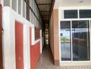 Corridor outside a building with tiled flooring and glass doors