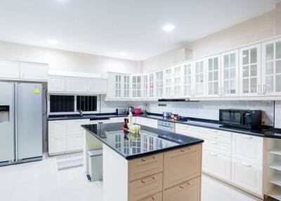 Modern kitchen with island, stainless steel appliances, and white cabinets