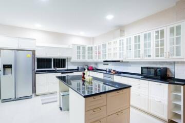 Modern kitchen with island, stainless steel appliances, and white cabinets