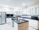 Modern kitchen with island, stainless steel appliances, and white cabinets