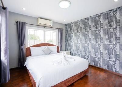 Bedroom with a double bed, patterned wallpaper, and air conditioning.