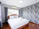 Bedroom with a double bed, patterned wallpaper, and air conditioning.