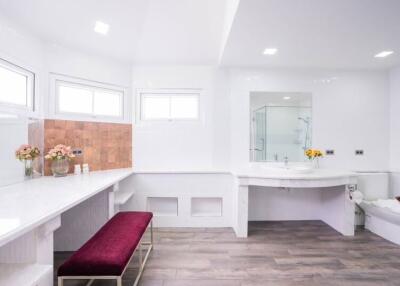 Spacious and modern bathroom with ample counter space and flowers