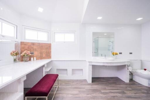 Spacious and modern bathroom with ample counter space and flowers