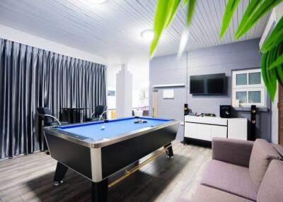 Modern recreation room with pool table and entertainment center