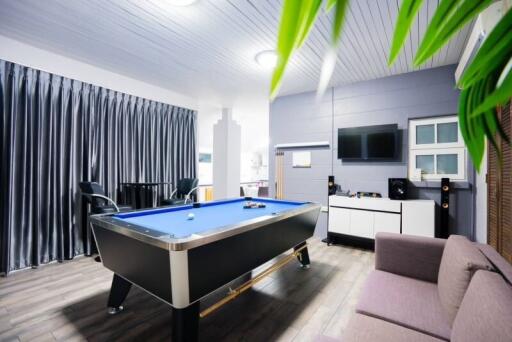 Modern recreation room with pool table and entertainment center