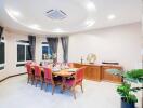 Spacious and elegant dining room with a set dining table, modern ceiling design, and large windows.