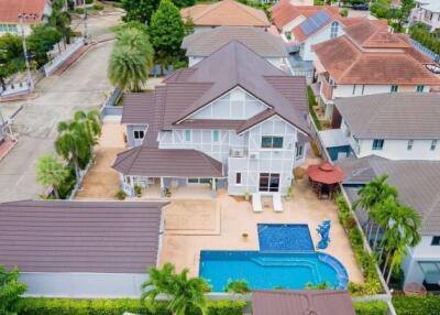 Aerial view of a spacious house with swimming pool and surrounding properties