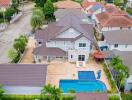 Aerial view of a spacious house with swimming pool and surrounding properties